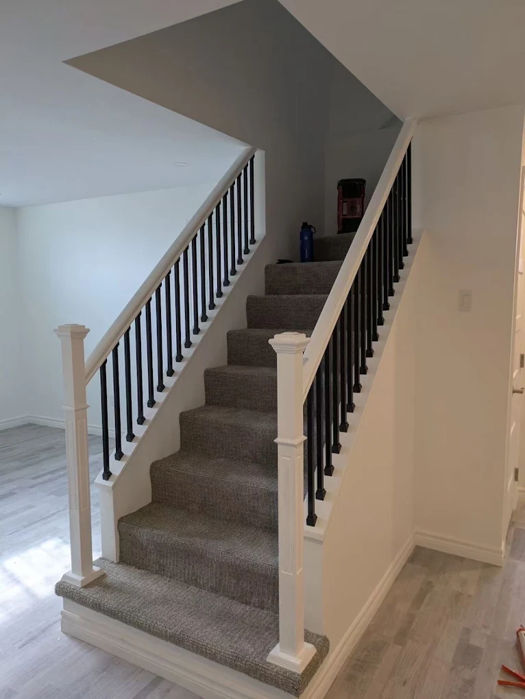 Escalier de sous-sol avec rampe en fer forgé par B&B Construction